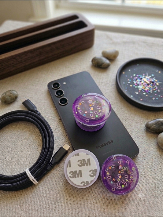 Sunset marble red orange purple swirl resin pop socket on black iPhone on wooden desk with succulent